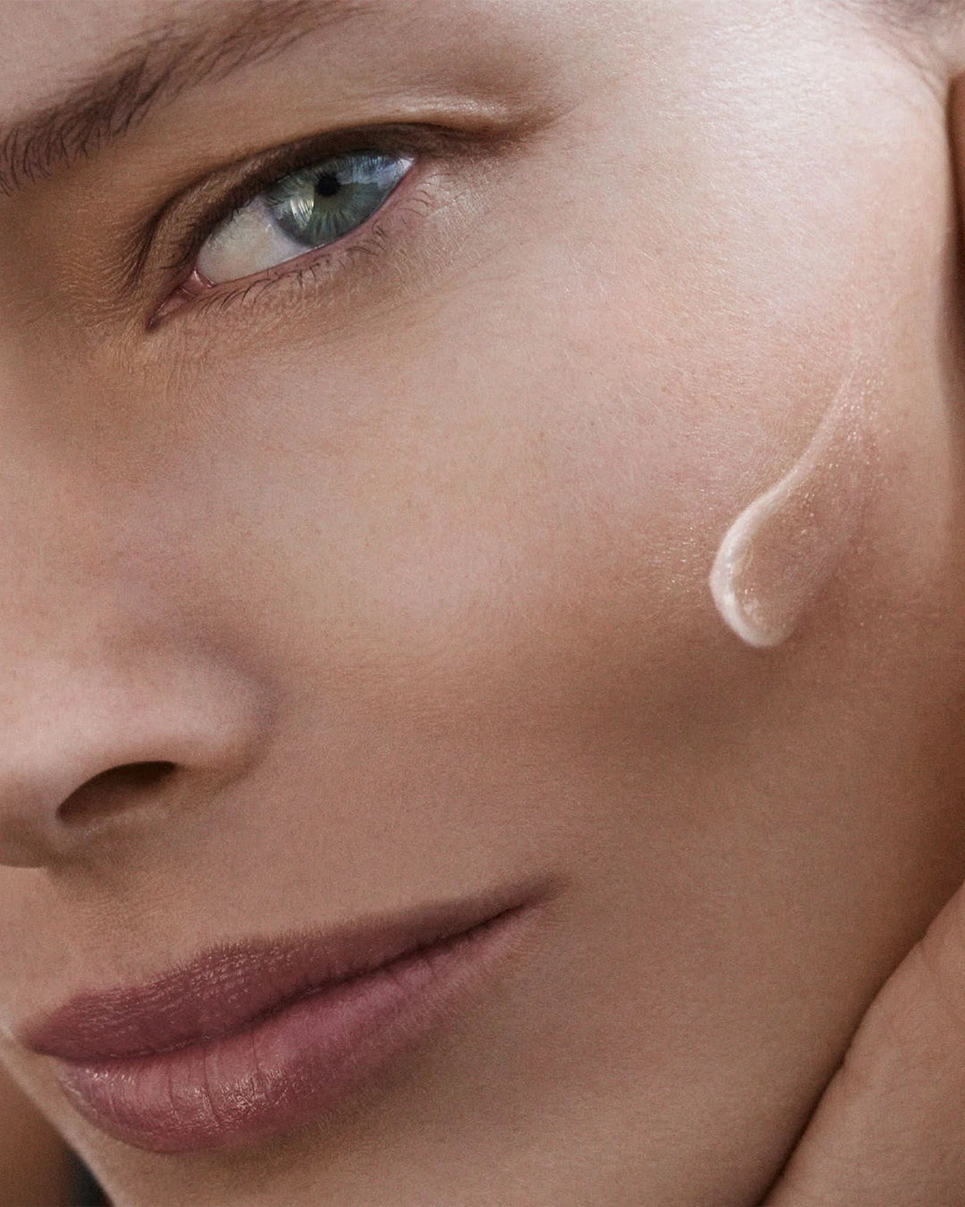 Close-up of a woman's face with a focus on her eye and skin texture.