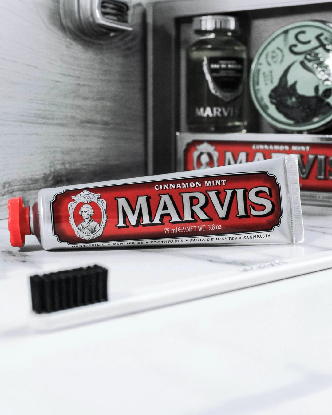 Marvis cinnamon mint toothpaste tube with a brush on a white surface