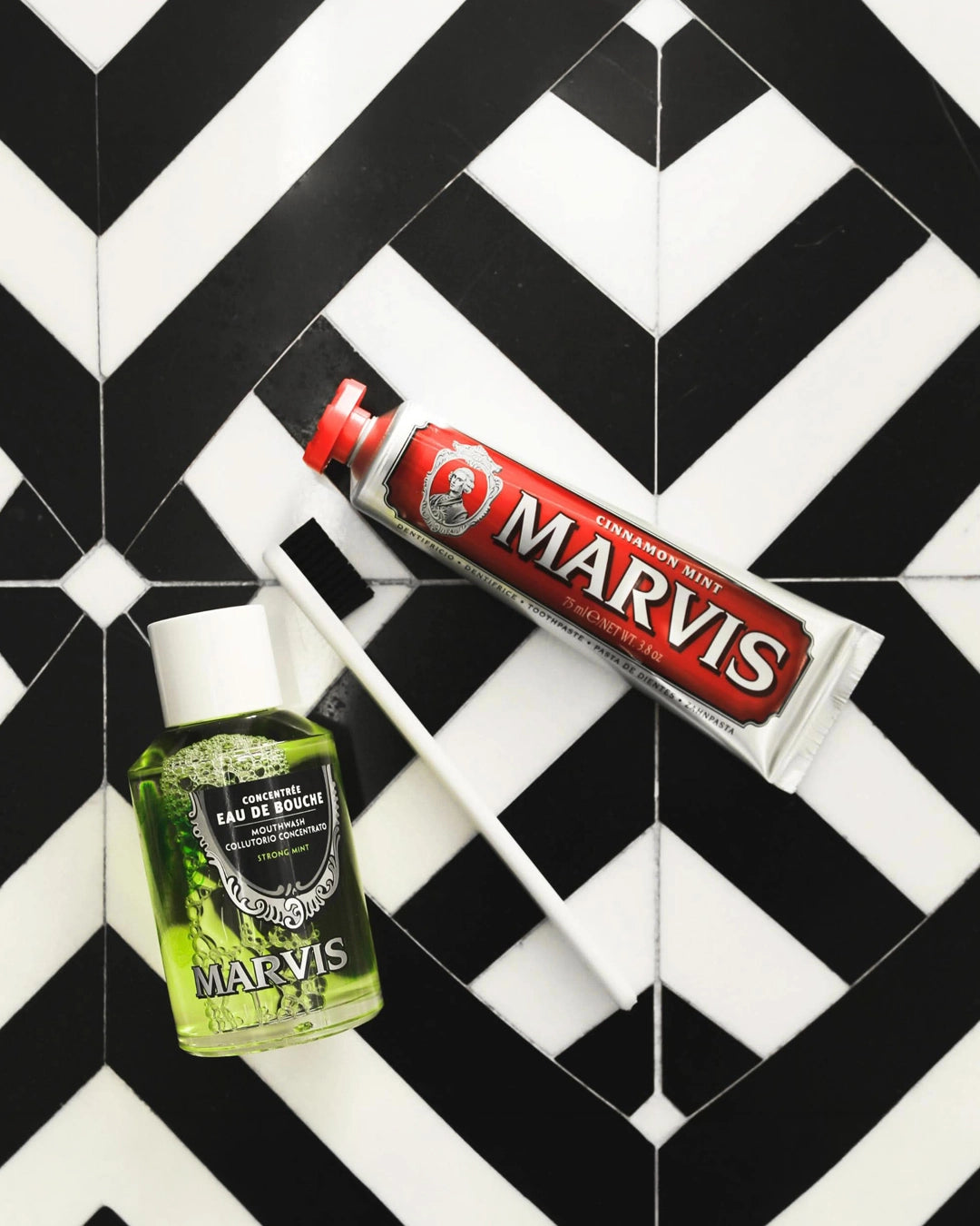 Marvis toothpaste and mouthwash on a black and white geometric patterned background