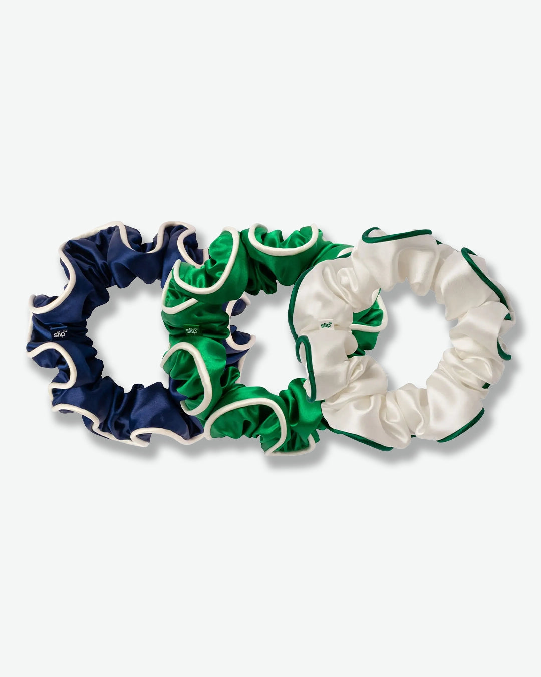 Three scrunchies in navy, green, and white on a white background