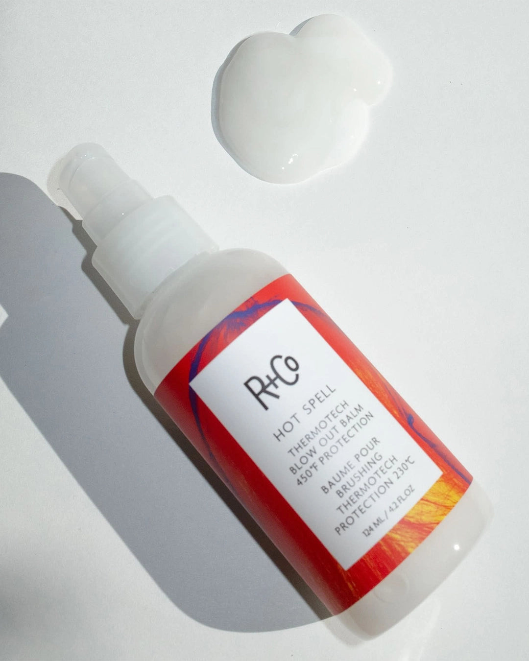 R+Co Hot Spell hair product bottle with red label on a white background