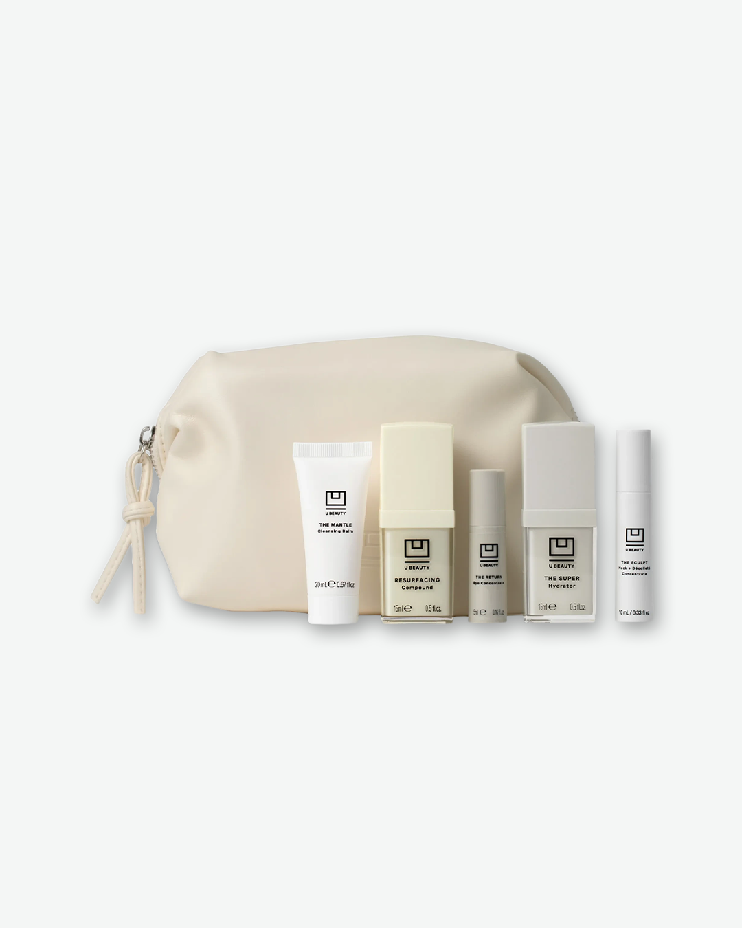Skincare product set with cream pouch and bottles on a white background