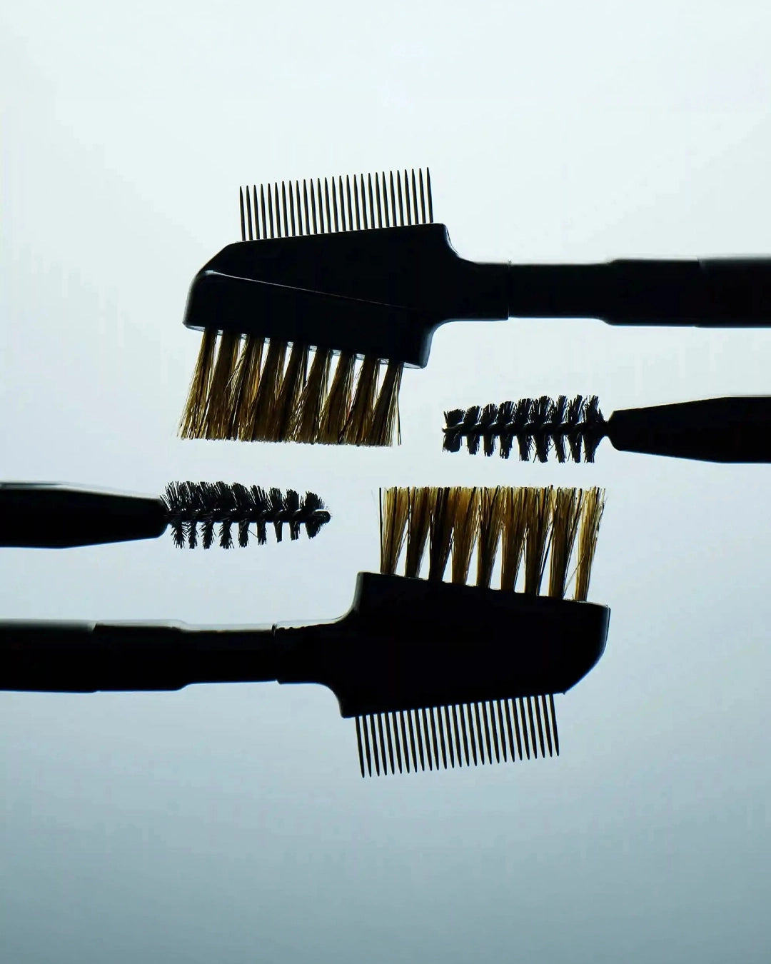 Set of black hairbrushes with bristle heads on a light gray background