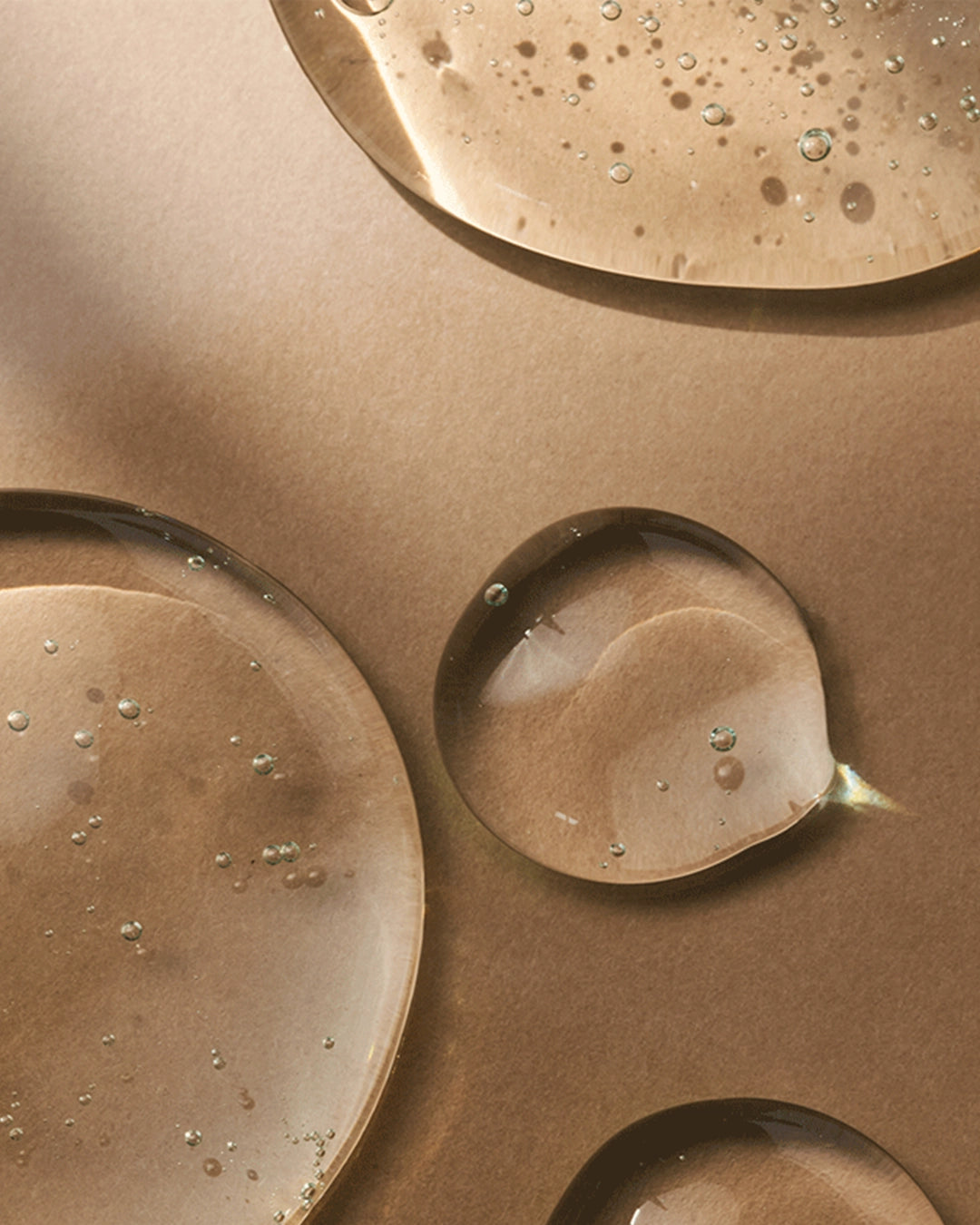 Close-up of bronze-colored metal surfaces with water droplets.