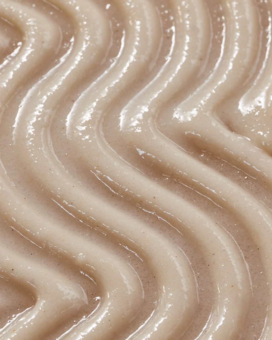Close-up of smooth, beige-colored cream with wavy patterns