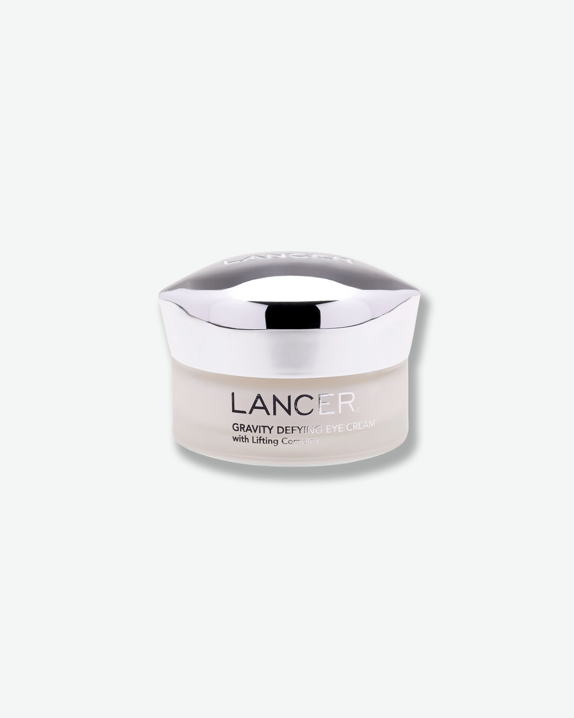 Front view of a compact Lancer Gravity Defying Eye Cream jar. The small container features a semi-opaque, frosted light cream base with dark grey lettering and a sculpted chrome metallic cap.