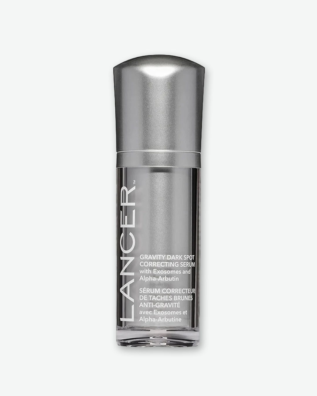 A product shot displaying the front view of a Lancer Gravity Dark Spot Correcting Serum bottle, centered against a plain light gray background. The cylindrical bottle features a metallic silver internal chassis housed within a clear plastic outer shell. The brand name "LANCER" is printed vertically in large, bold white capital letters along the left side, beside white text detailing the product title and its French translation. The bottle is capped with a matching metallic silver dome top.