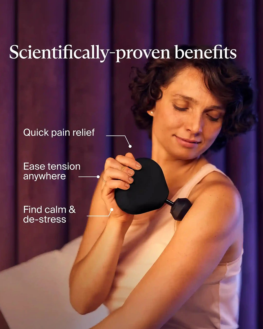 Woman holding a black handheld device with text about its scientifically-proven benefits on a purple curtain background.