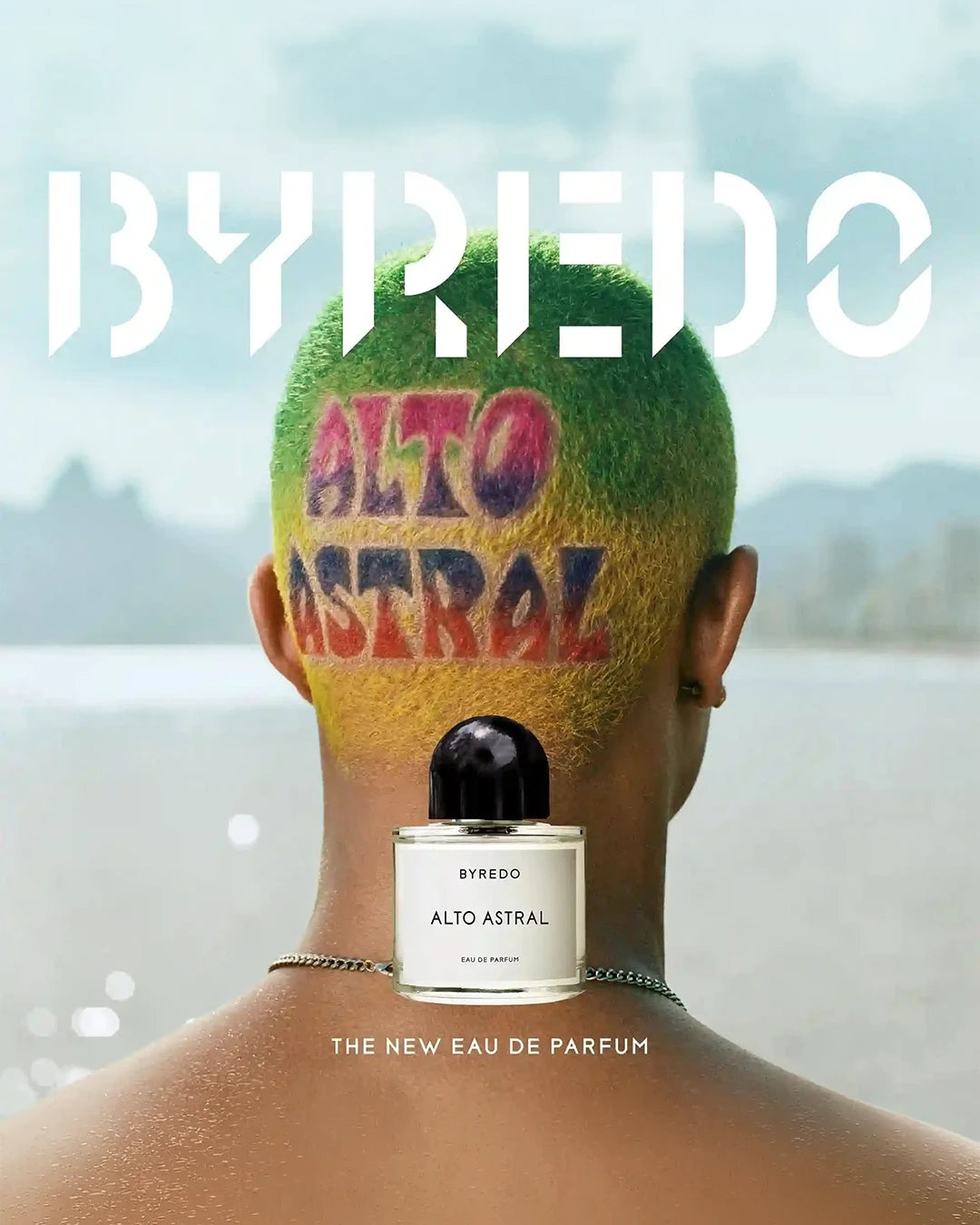 Back of a colorful shaved head with Alta Astral drawn on and Byredo Alto Astral perfume bottle