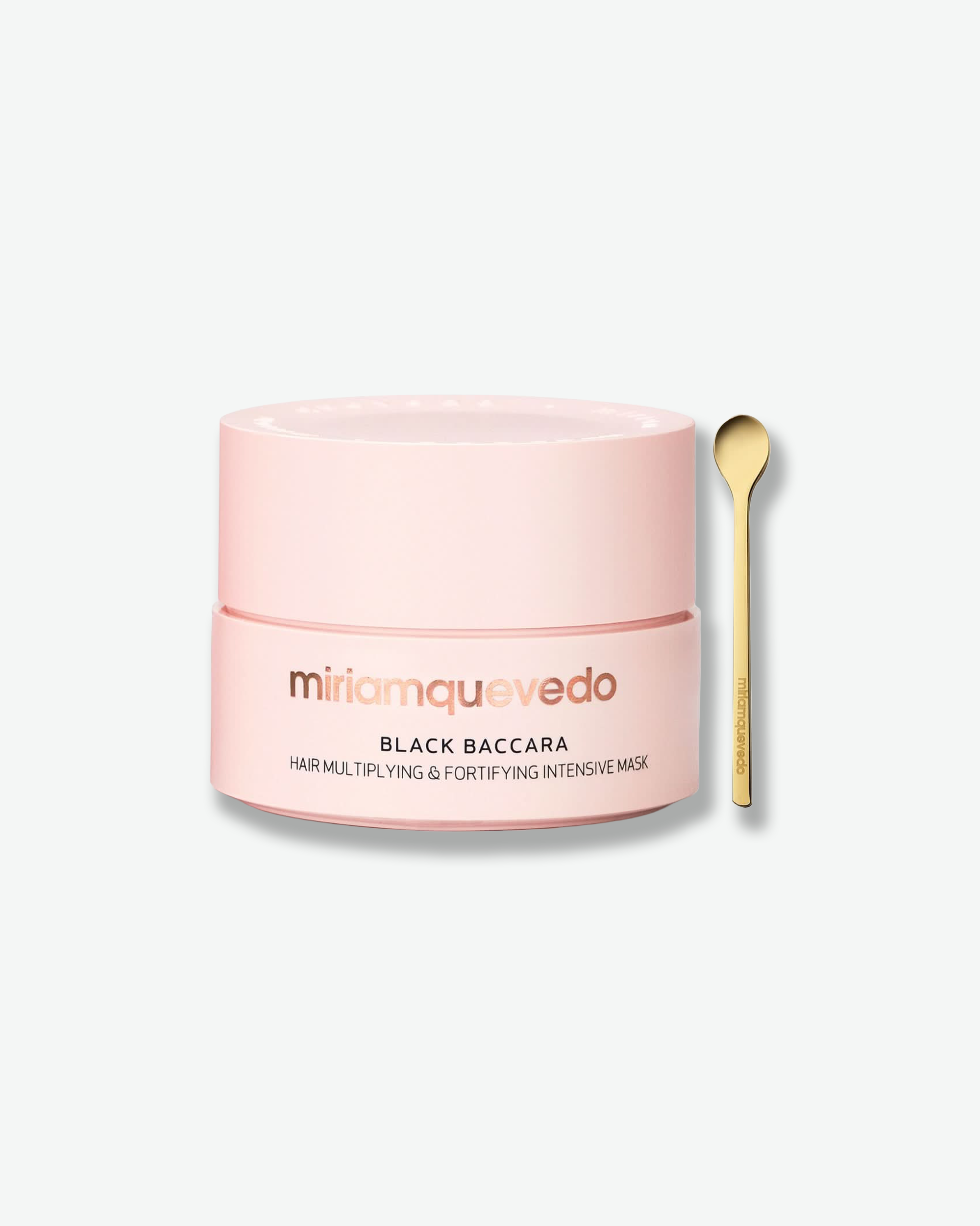 Pink jar of Miriam Quevado hair mask with a gold spoon on a white background