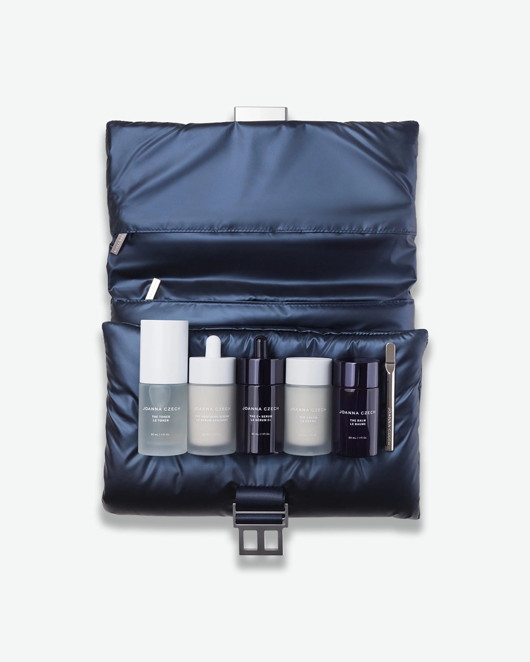 Set of skincare products in a navy blue travel case on a white background