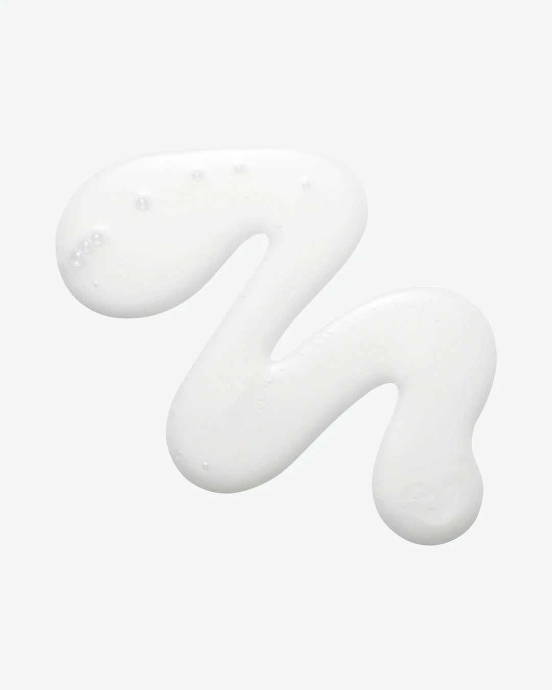 White cream or gel in a wavy pattern on a light gray background