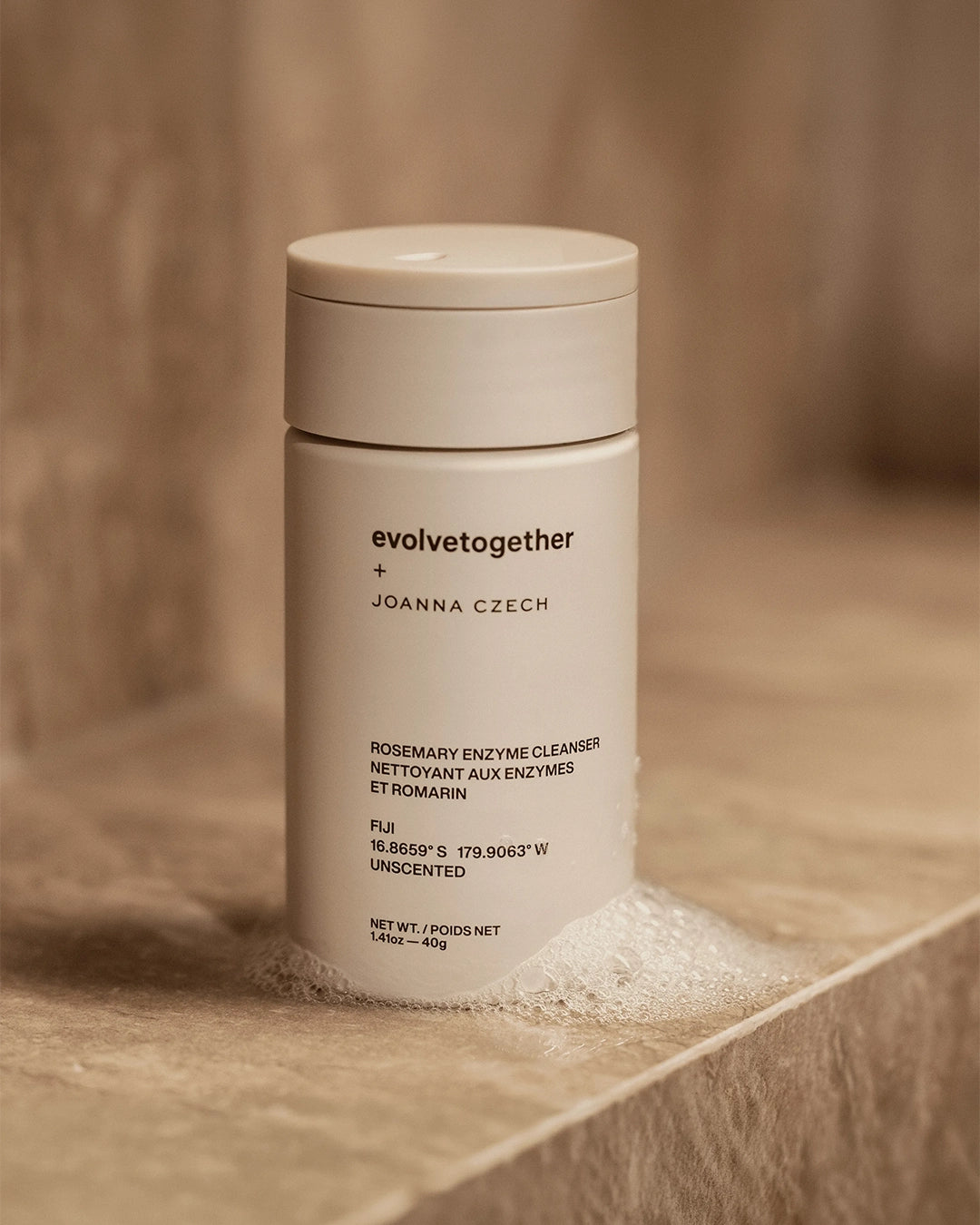 Beige skincare product container with 'evolvetogether' branding on a wooden surface.