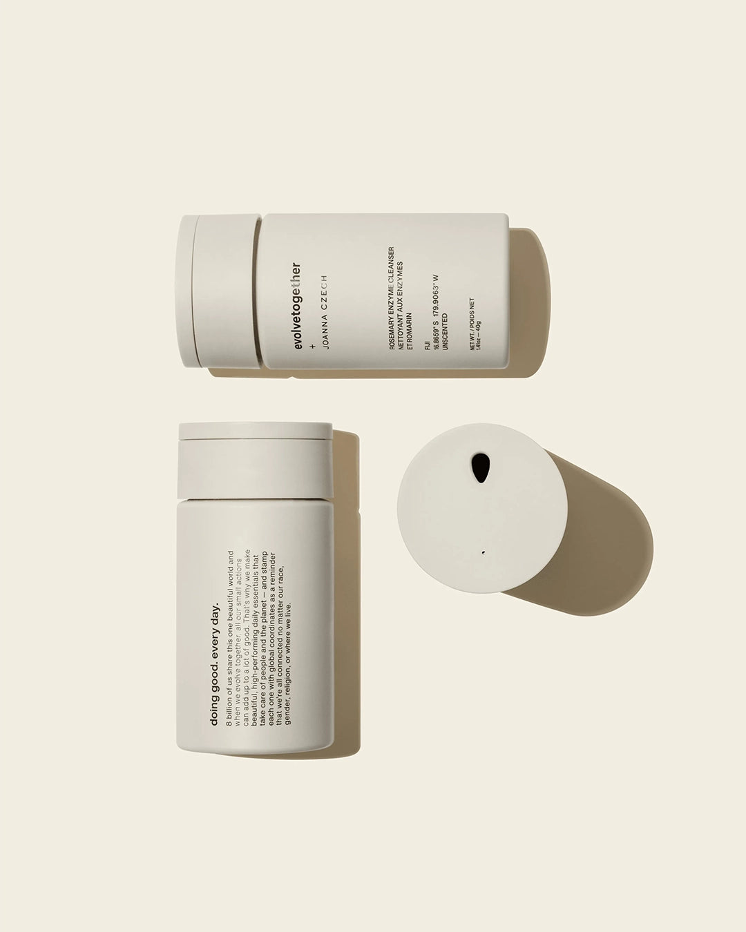 Three white cylindrical containers with black text on a beige background