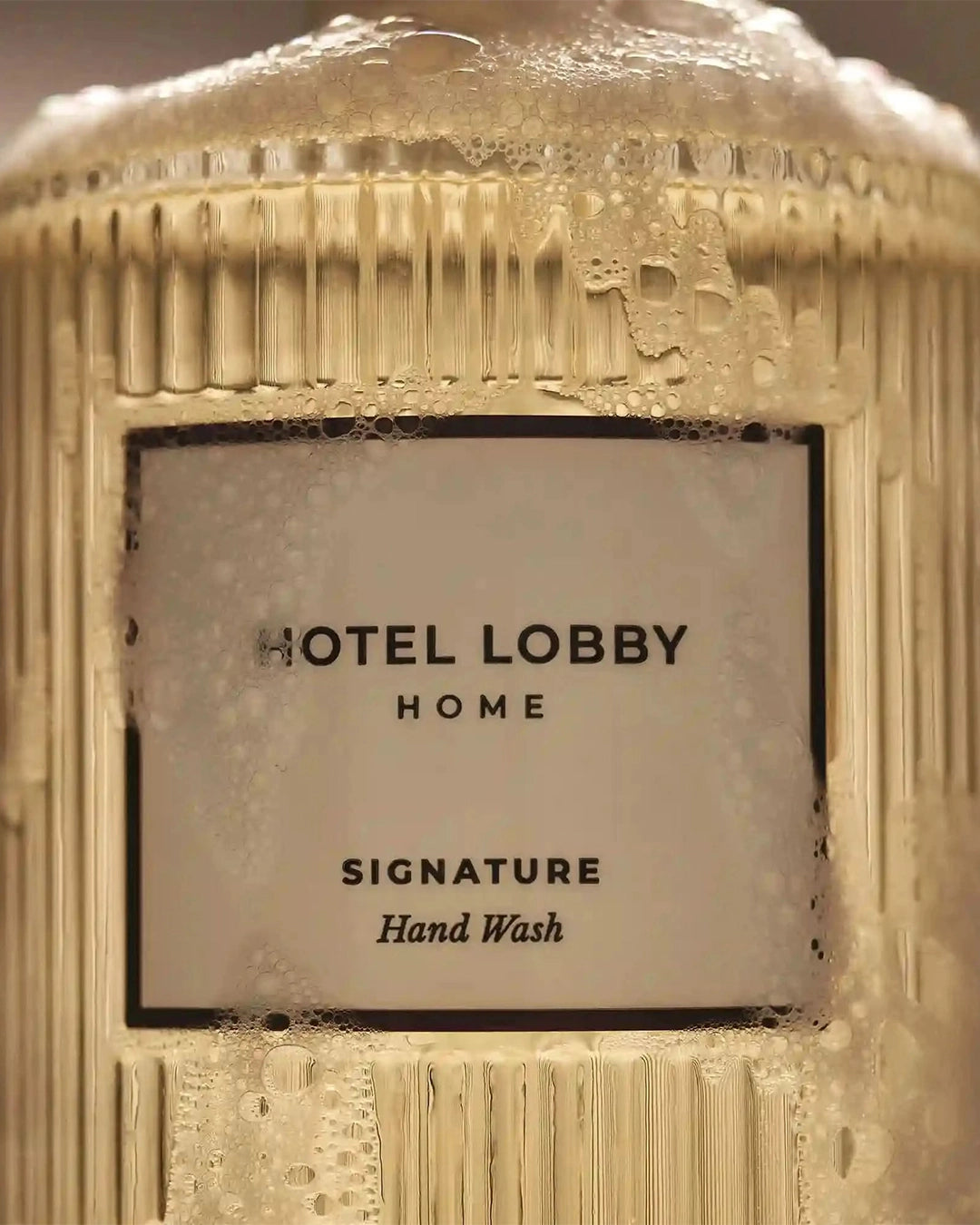 Hand wash bottle with 'Hotel Lobby Home' label on a textured surface