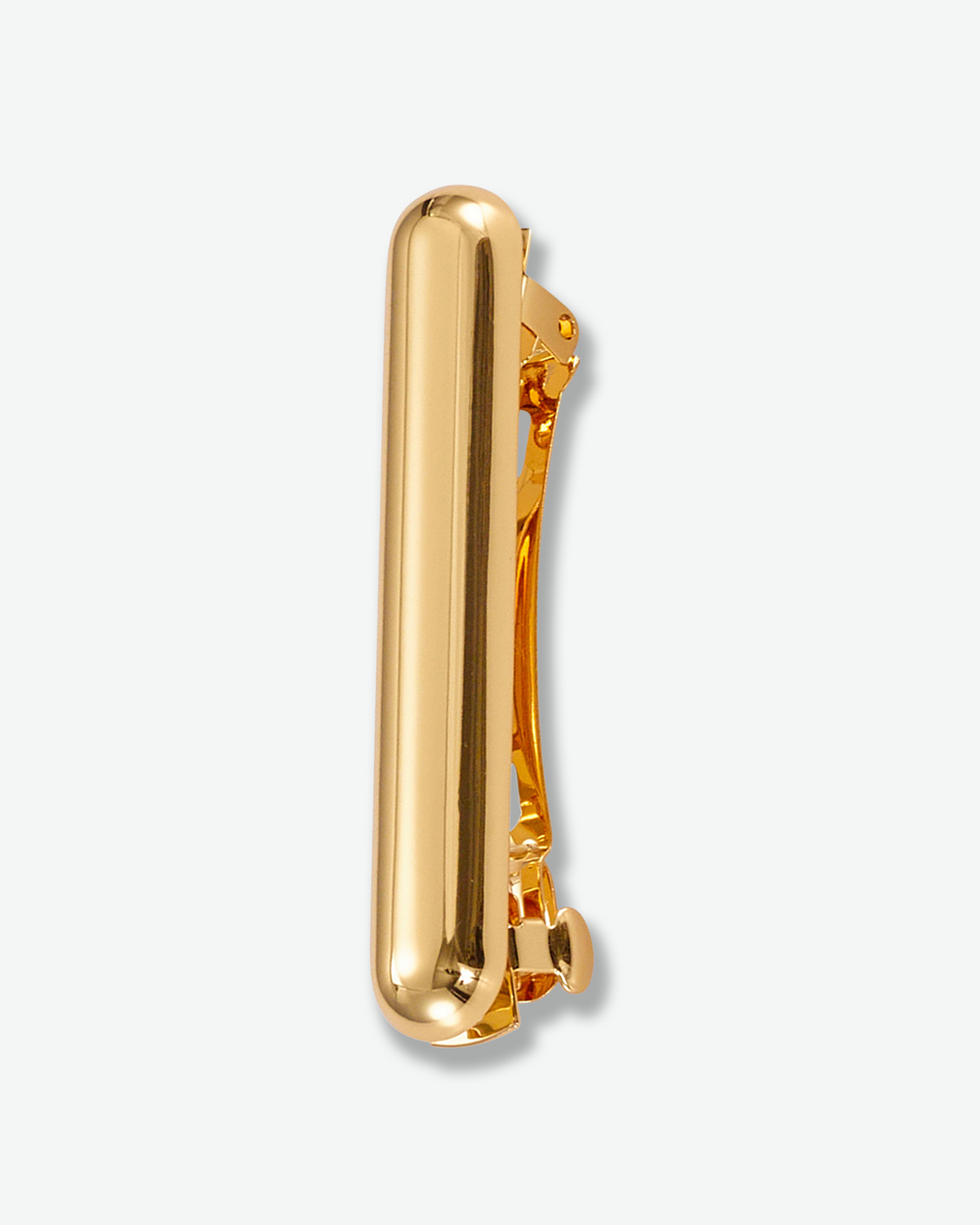 A polished gold metal hair clip shown from the side against a light gray background.