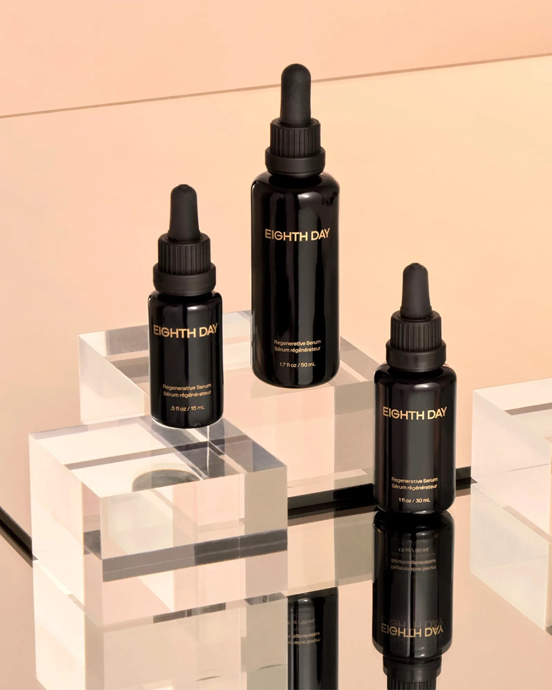 Three black bottles of Eighth Day skincare on a reflective surface with a beige background