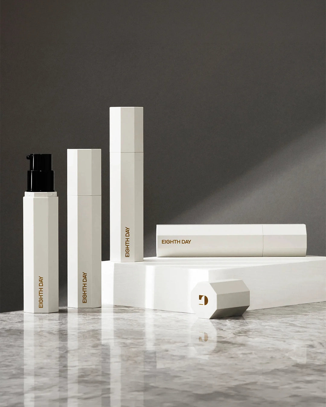 Eighth Day skincare products on a marble surface with a dark background
