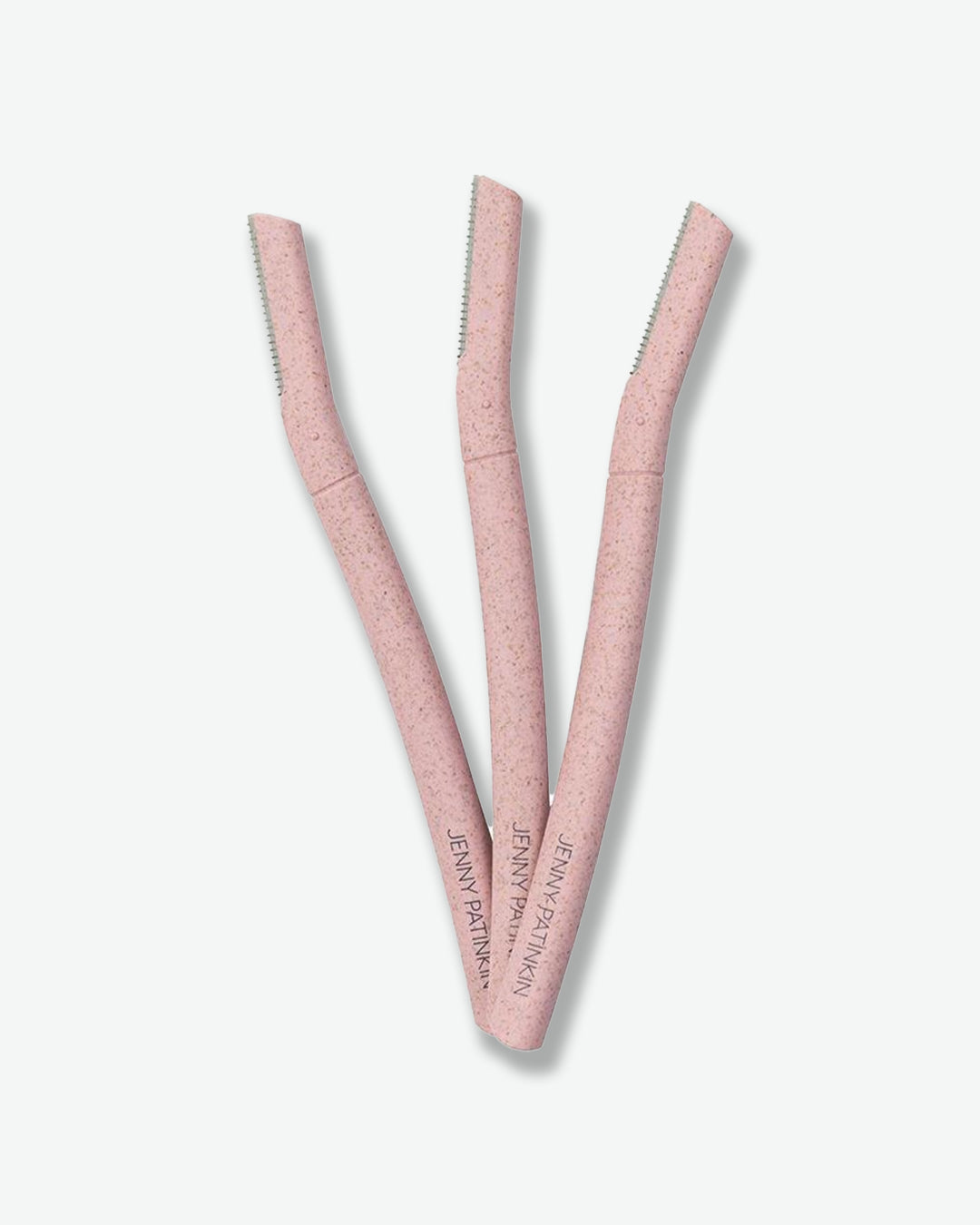 Three facial razors are displayed against a light gray background. Each razor features a speckled blush-pink handle with a slim, angled blade designed for gentle facial hair removal and precise grooming. The tools are arranged in a fan shape, highlighting their ergonomic design and travel-friendly size.