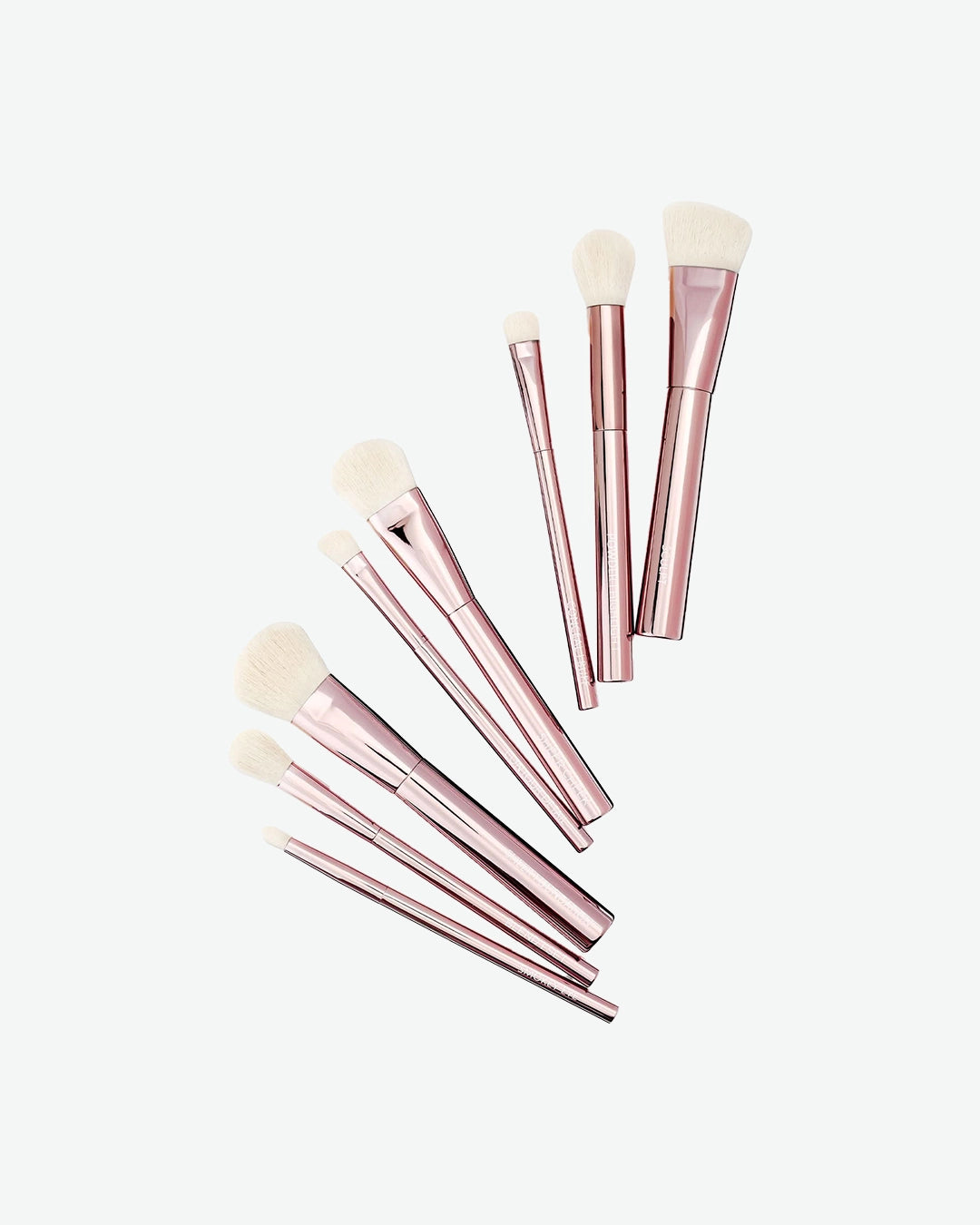 Set of rose gold makeup brushes on a white background