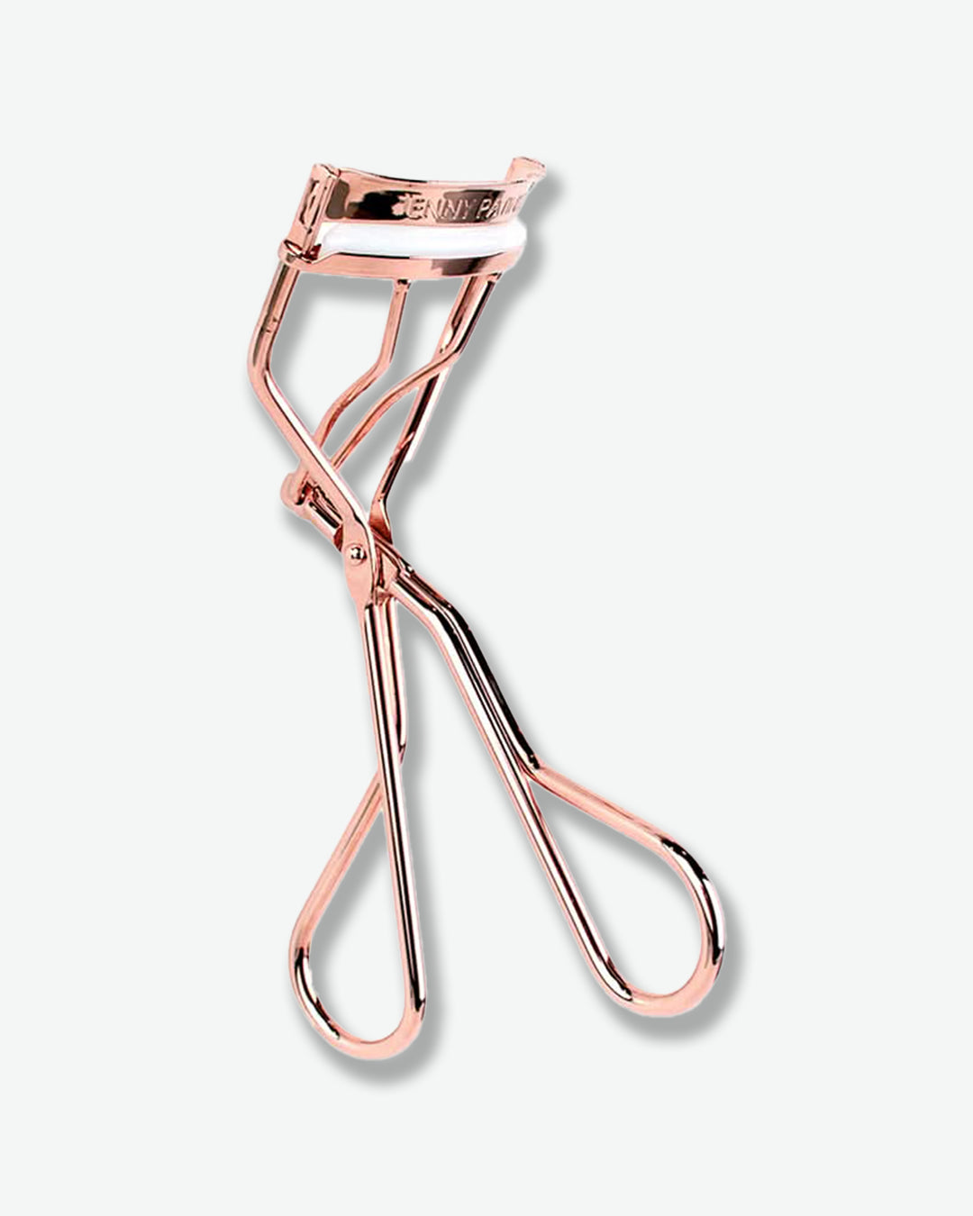 Rose gold eyelash curler on a white background