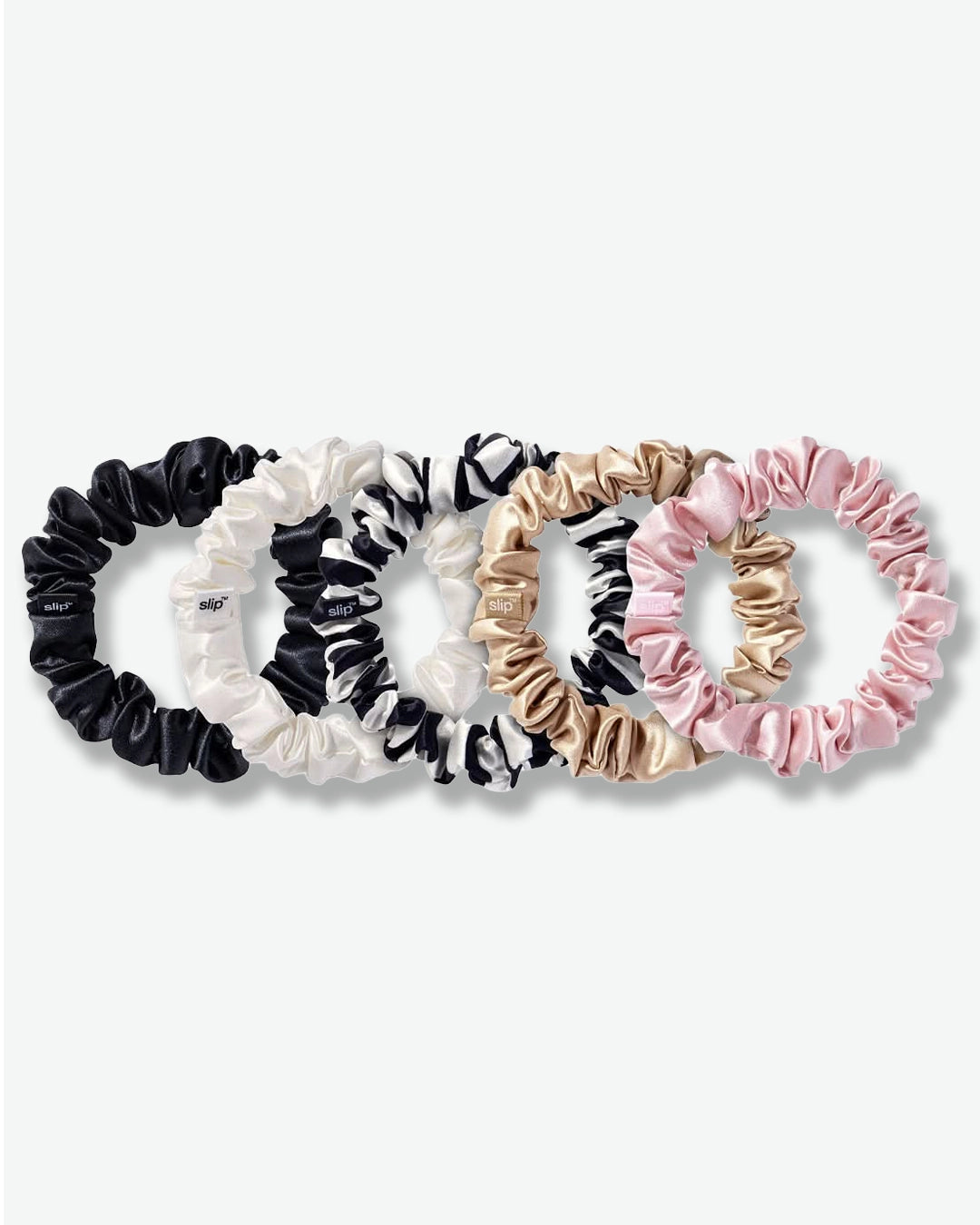 Set of five scrunchies in black, white, beige, and pink on a white background