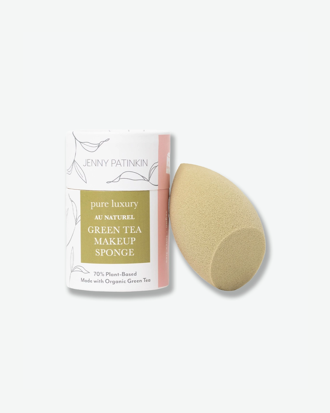A product shot of a Jenny Patinkin Pure Luxury Au Naturel Green Tea Makeup Sponge set against a plain light gray background. On the left is the cylindrical white-and-pink cardboard packaging box featuring line-art leaf illustrations and an olive-green label. On the right, leaning against the box, is the tear-shaped olive-green makeup sponge with a flat, angled edge on one side.