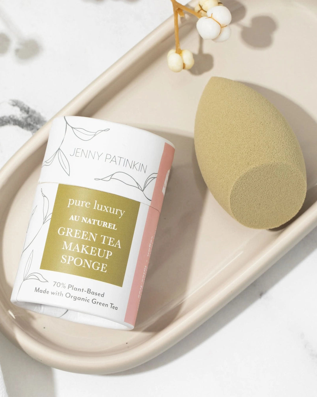 Green tea makeup sponge packaging with a sponge on a tray