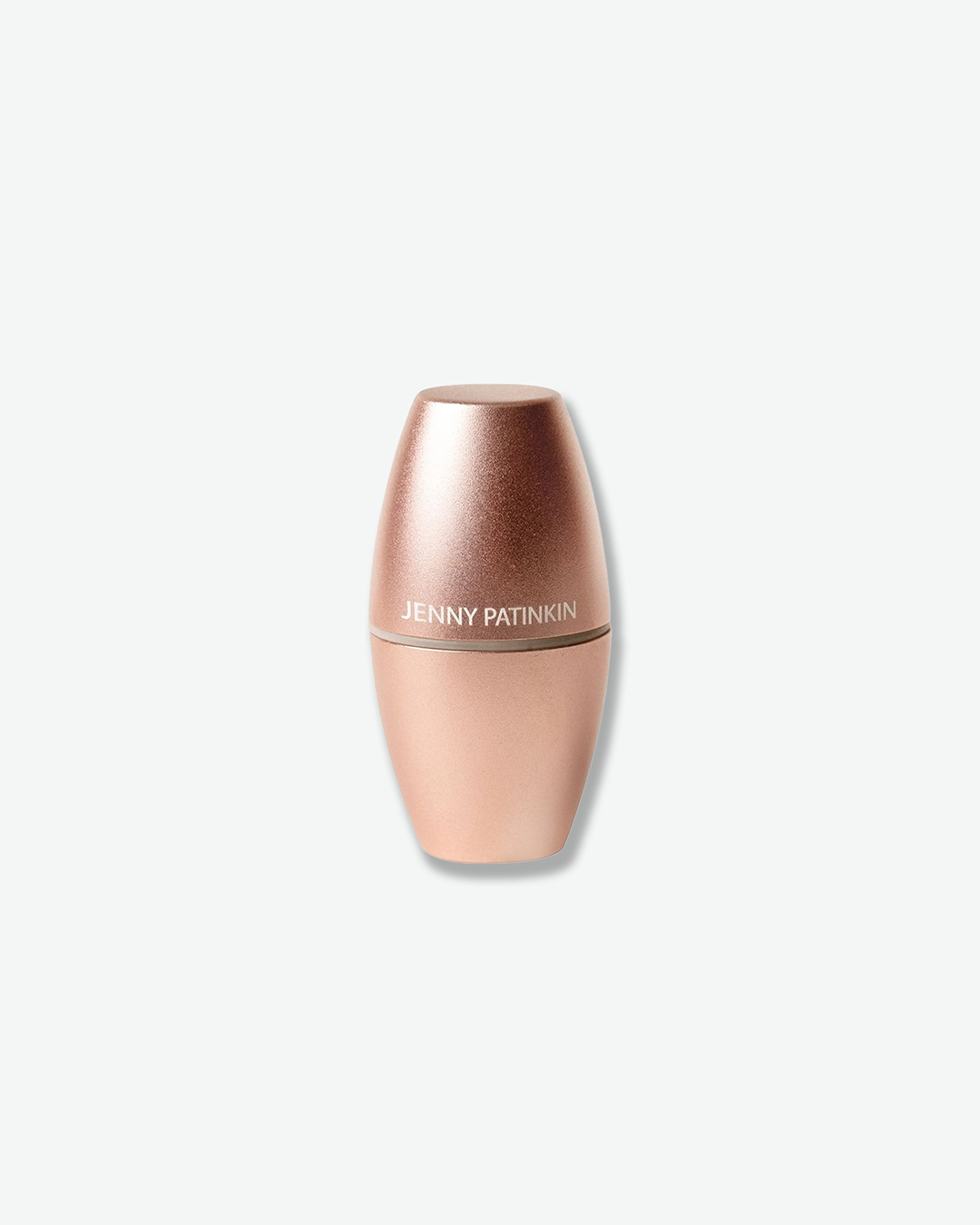 A product shot of a closed Jenny Patinkin tool centered against a plain light gray background. The compact, capsule-shaped device is finished in a smooth, metallic rose-gold color with the brand name "JENNY PATINKIN" printed in clean white text across the middle where the cap meets the base.