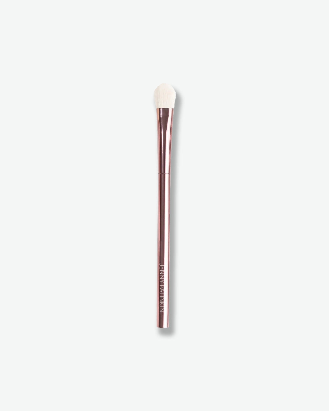 Makeup brush with white bristle head on a light gray background