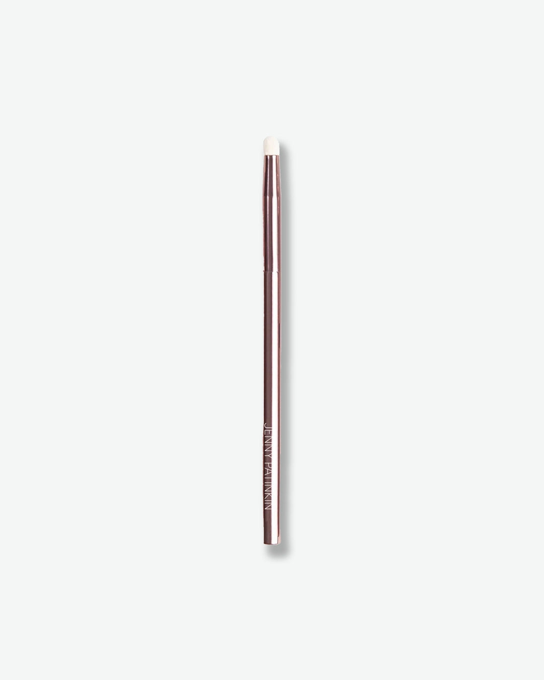 A slim makeup brush is displayed against a light gray background. The brush features a metallic rose-toned handle with a small rounded white applicator tip, designed for precise application and blending of eye makeup products. Its sleek, minimalist design highlights both functionality and professional craftsmanship.
