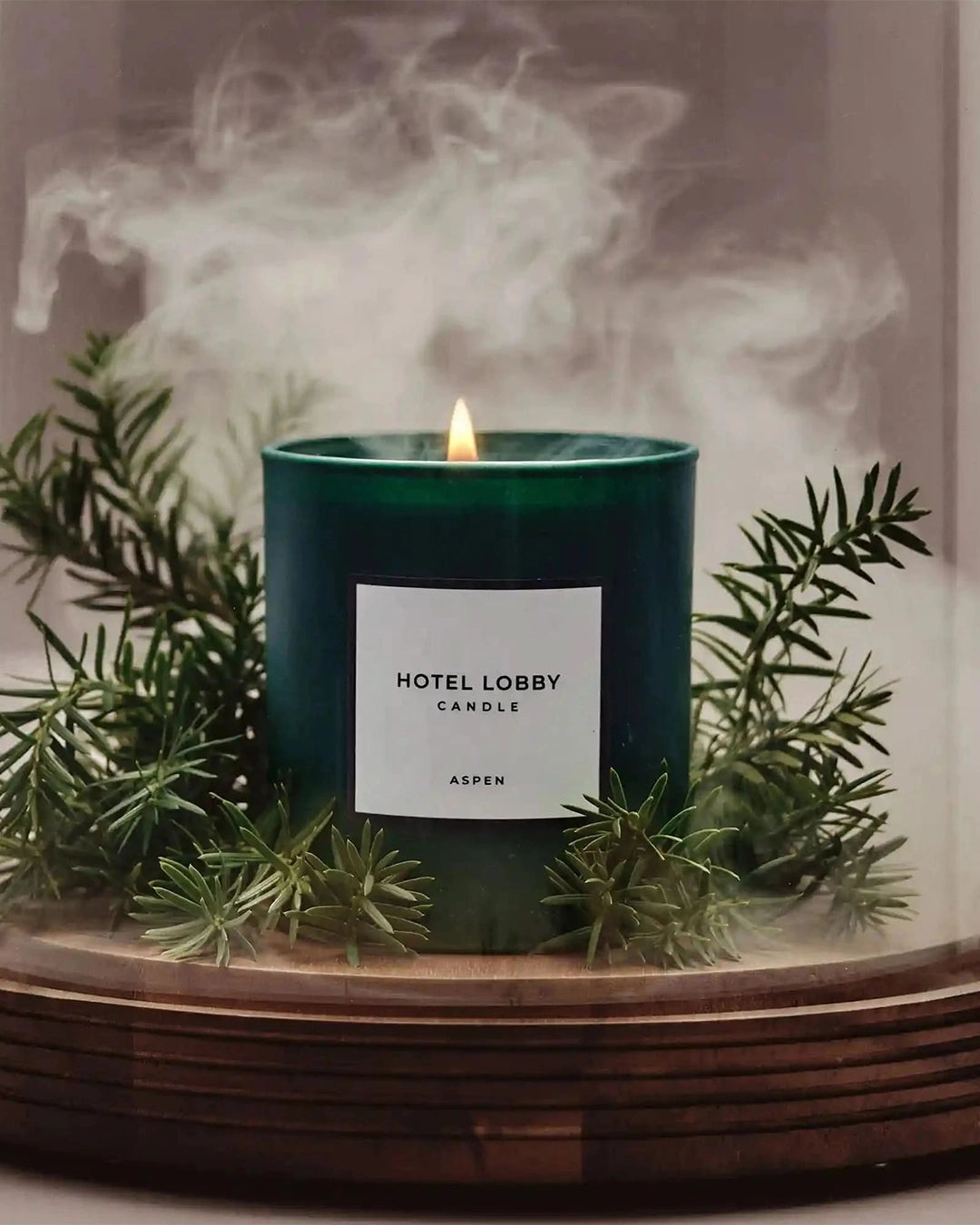 Hotel Lobby candle with a label on a wooden surface with greenery