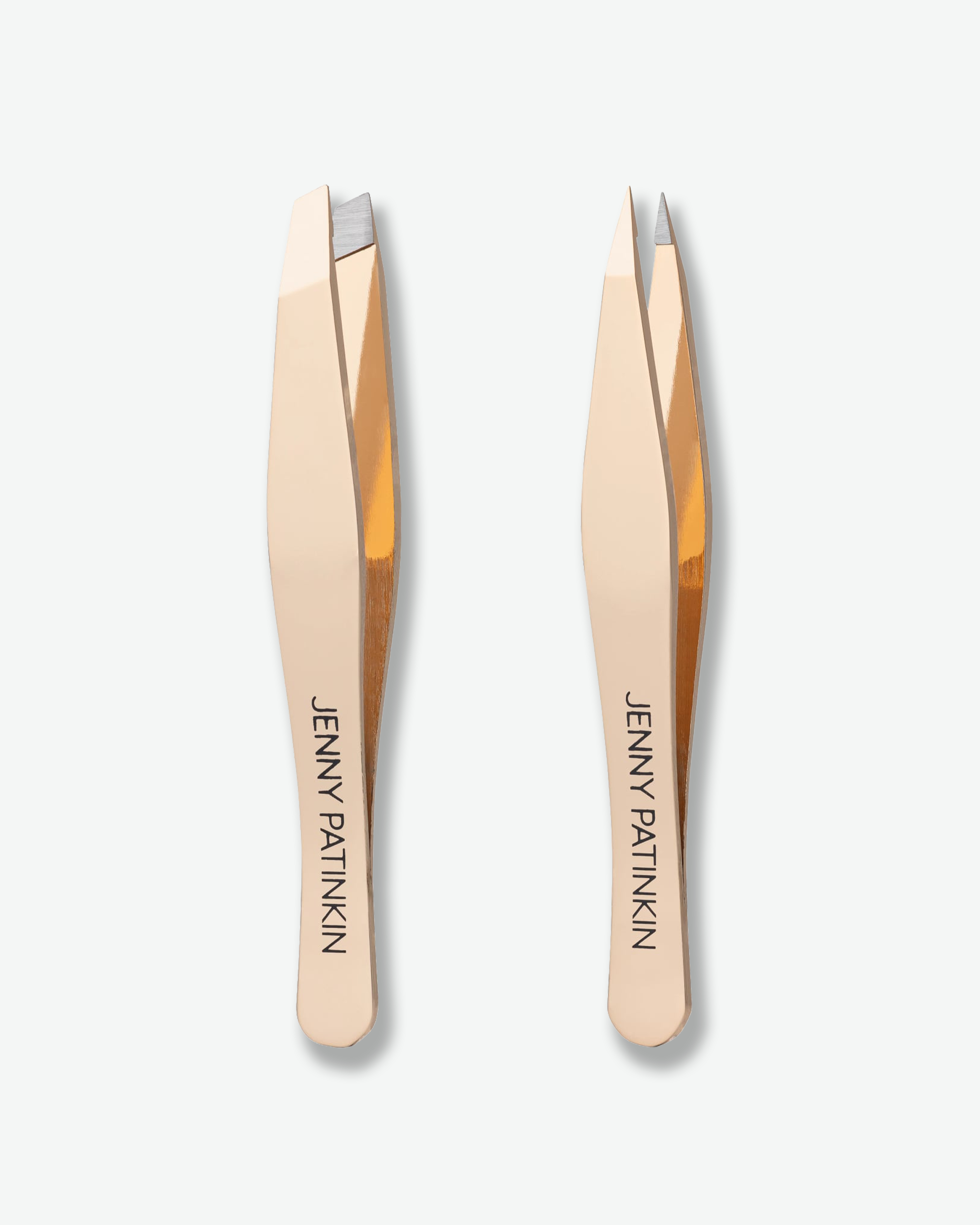 Two rose gold metal tweezers with black printed 'JENNY PATINKIN' branding, shown side-by-side on a light gray background.