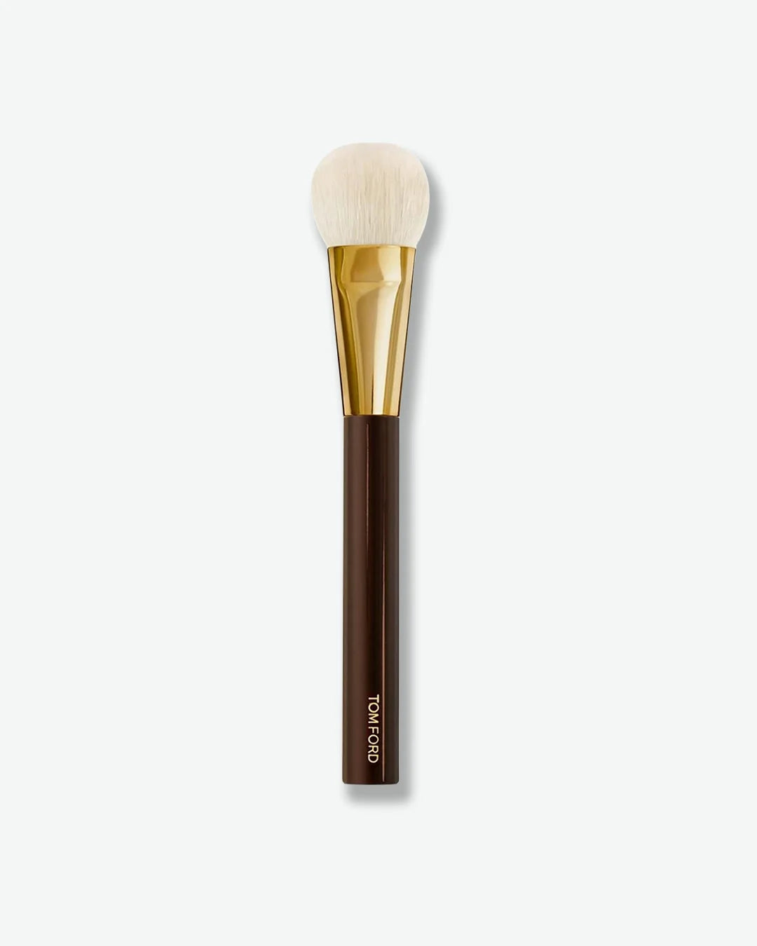 Makeup brush with brown handle and gold ferrule on a white background