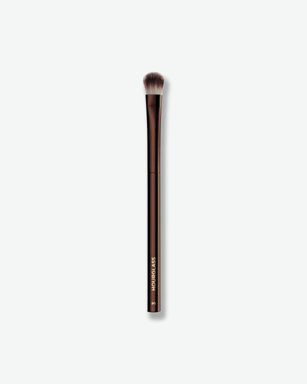 A slim makeup brush with a dark bronze handle and rounded, densely packed bristles. The brush features a small, domed head designed for precise eyeshadow application and blending. Displayed against a light gray background.