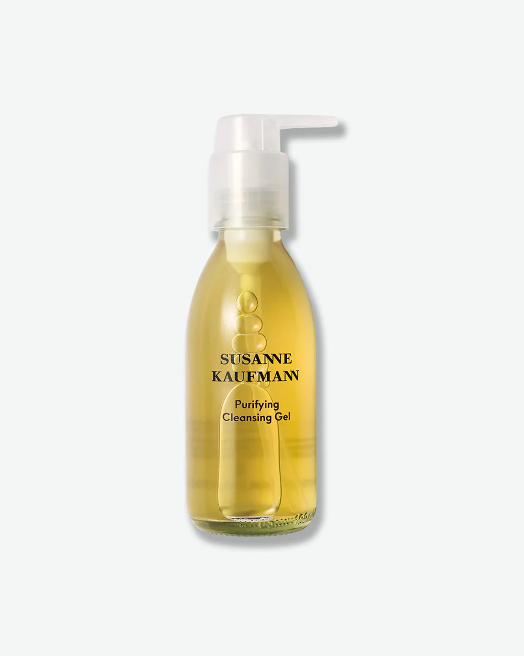 A product shot of a Susanne Kaufmann Purifying Cleansing Gel bottle, centered against a plain light gray background. The clear glass bottle contains a vibrant, translucent golden-yellow gel formula with visible air bubbles near the pump stem. It features a clear pump dispenser and black text branding on the front.