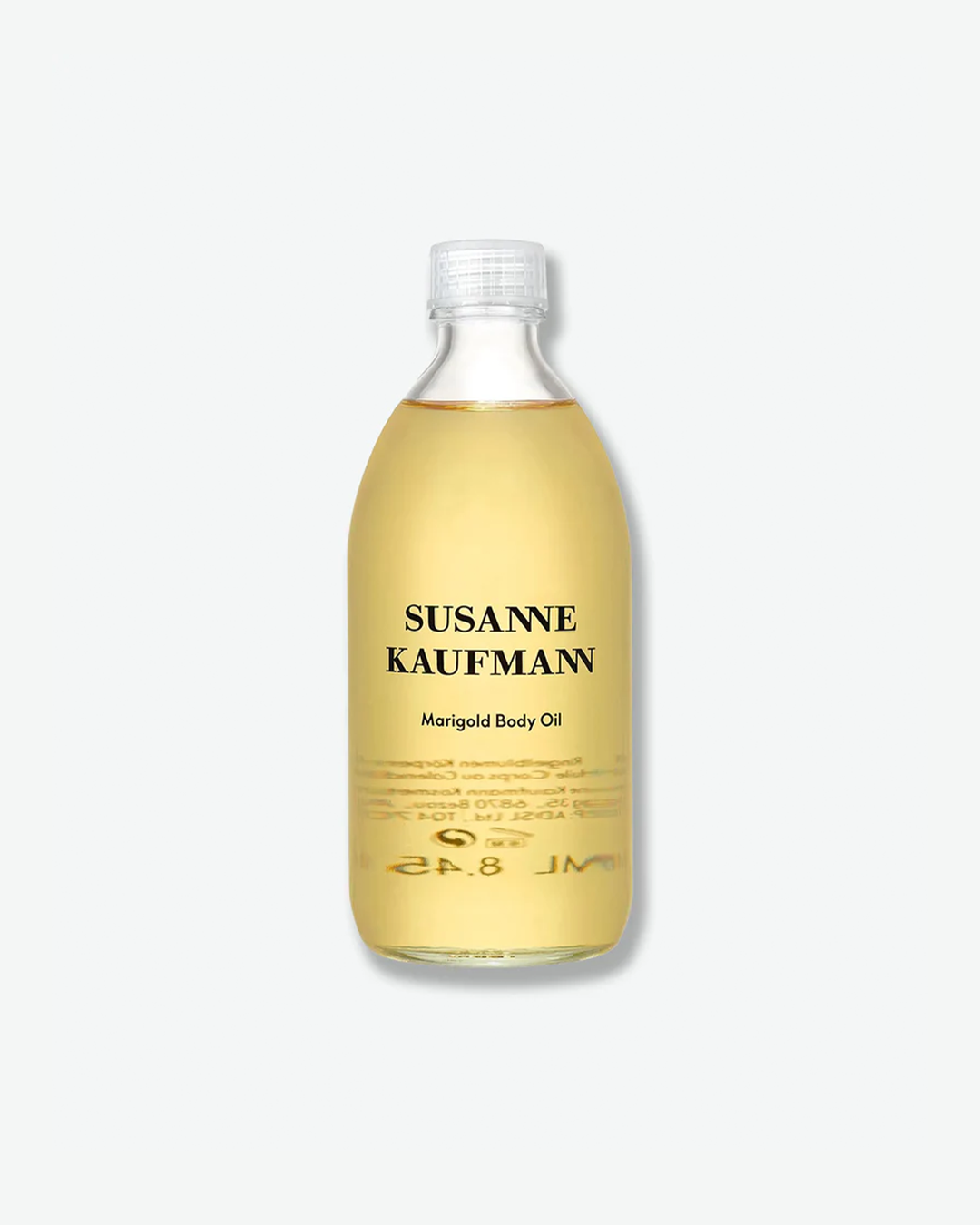 A product shot of a Susanne Kaufmann Marigold Body Oil bottle, centered against a plain light gray background. The curved clear glass bottle holds a translucent, bright golden-yellow body oil and is sealed with a clear plastic ribbed cap. The front displays clean black typography detailing the brand name and product title.