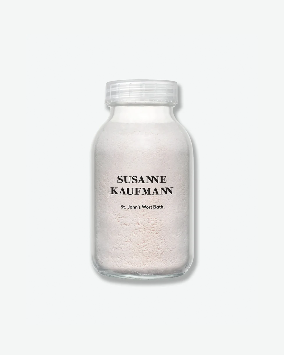 A product shot of a Susanne Kaufmann St. John's Wort Bath container, centered against a plain light gray background. The wide-mouthed clear glass jar is filled to the neck with an opaque, pale pinkish-white bath powder. It features the brand name in black serif typography printed directly on the glass above the product name, and is sealed with a clear plastic ribbed screw cap.