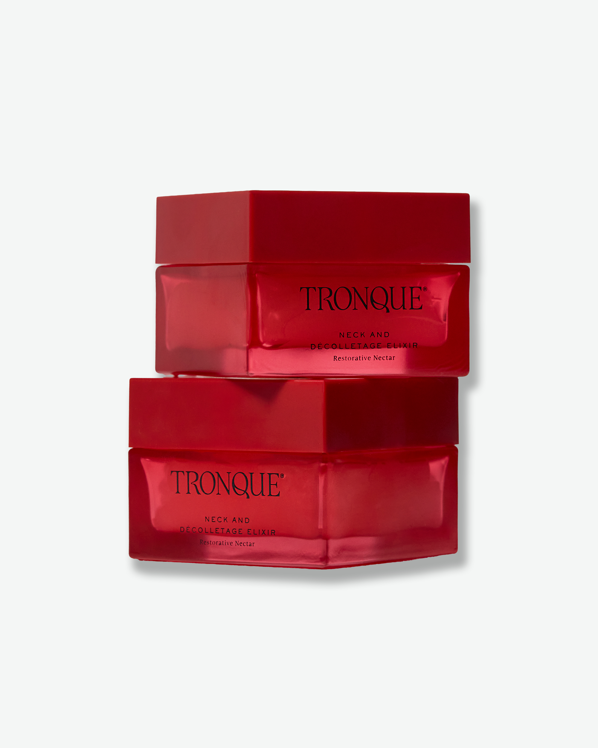 Two stacked red Tronque Neck and Décolletage Elixir jars on a clean light background.