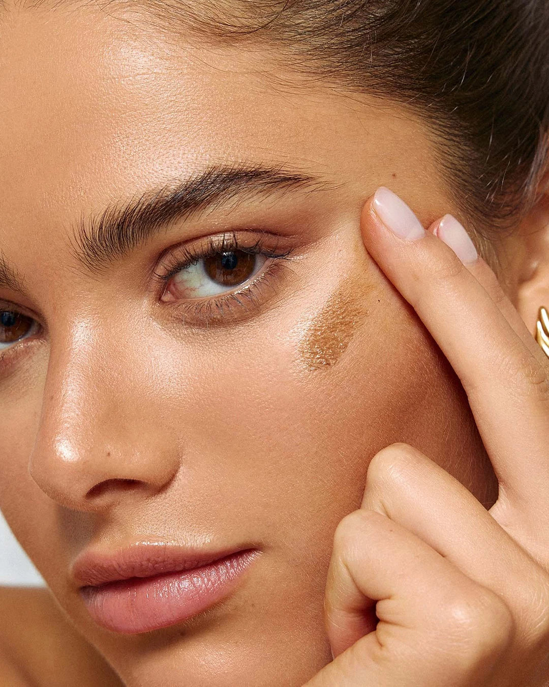 Close-up of a person applying makeup to their face