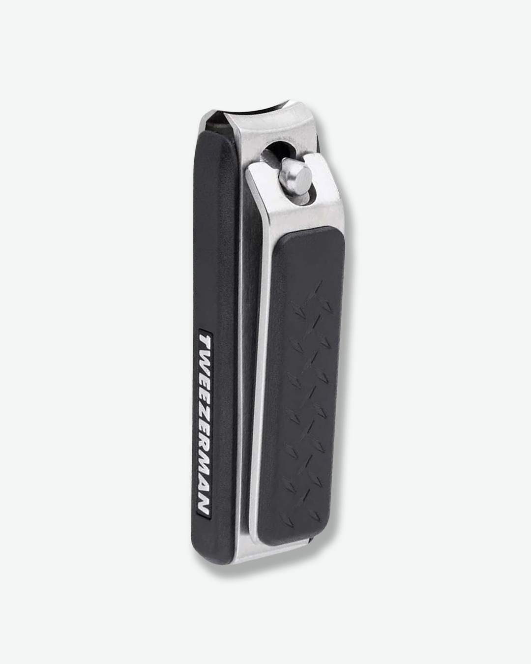 Three-quarter angled view of a pair of Tweezerman toenail clippers standing vertically. The grooming tool features a brushed stainless steel metal frame accented by textured, black non-slip grip pads on the lever and base, with the brand name printed along the side.