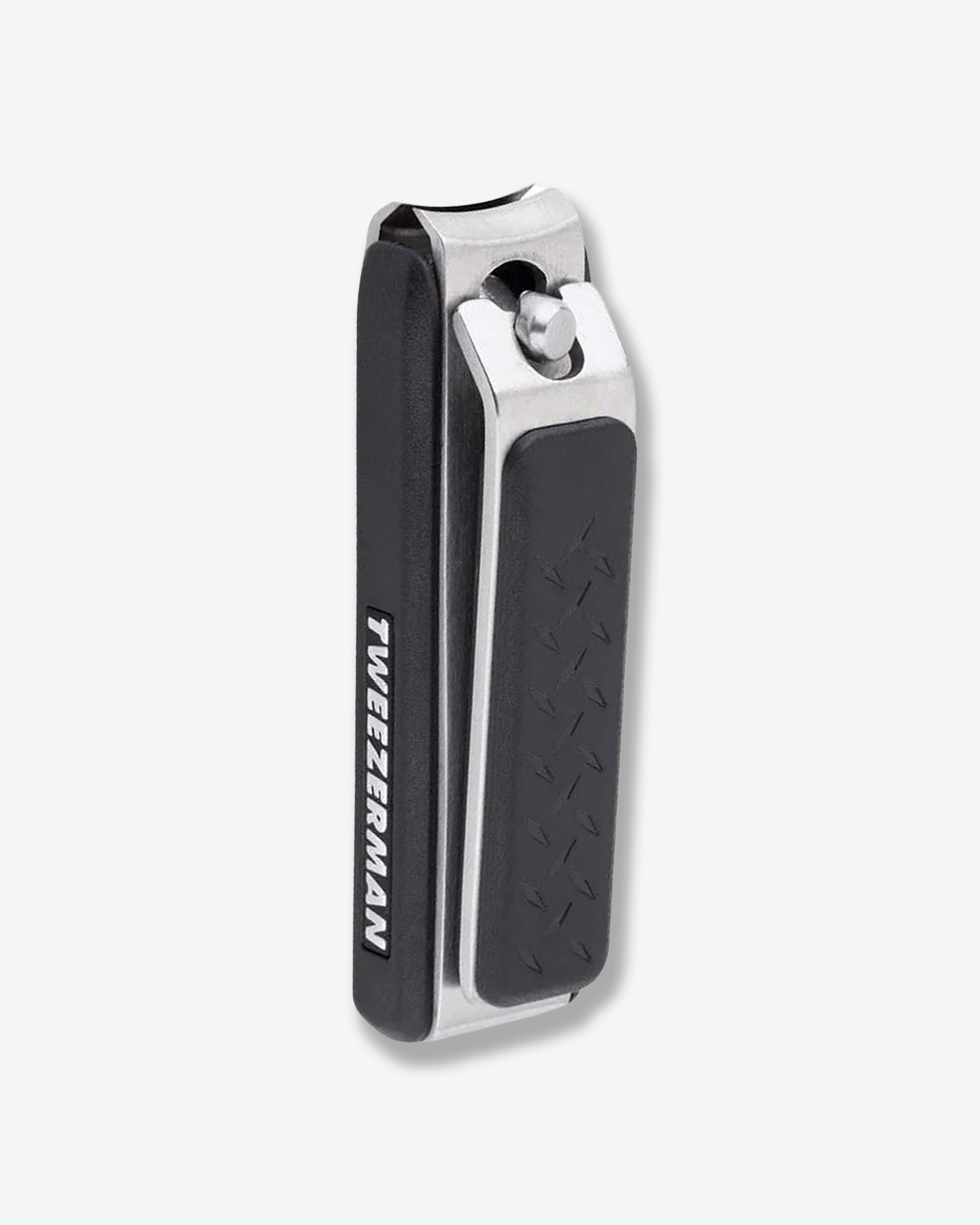 Three-quarter angled view of a pair of Tweezerman toenail clippers standing vertically. The grooming tool features a brushed stainless steel metal frame accented by textured, black non-slip grip pads on the lever and base, with the brand name printed along the side.