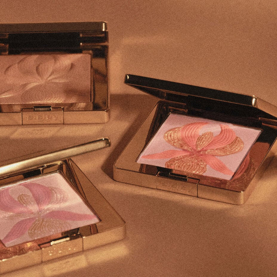 Compact powder cases with floral design on a brown background