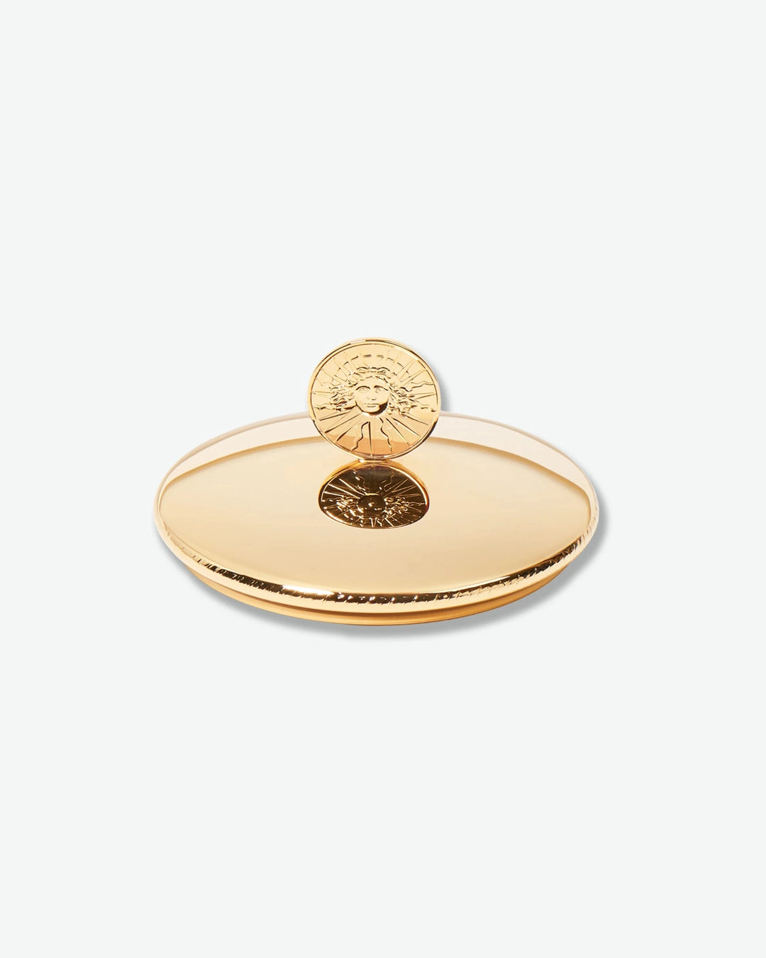 Gold decorative object with circular design on a white background