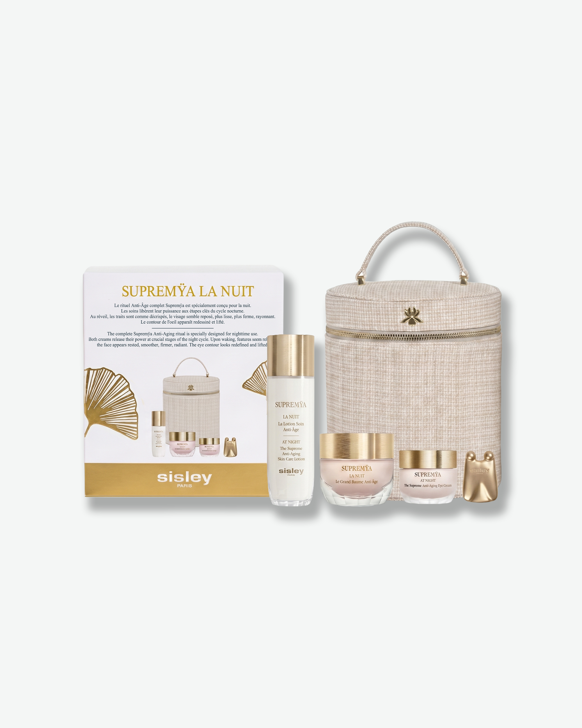A Sisley Paris Supremÿa La Nuit gift set featuring skincare products with gold accents, a small gold massager tool, a structured beige vanity case, and matching product box.