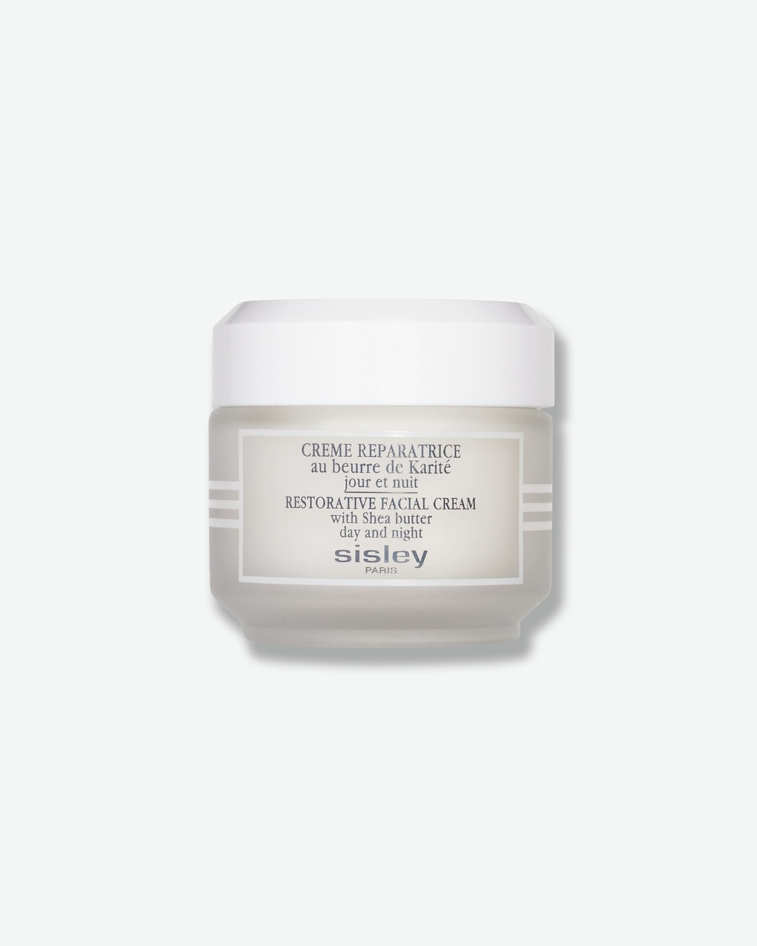 Front view of a Sisley Paris Restorative Facial Cream jar against a plain gray background. The cylindrical container features a frosted, light-grey glass base accented by white horizontal stripes on the sides, a rectangular white label with dark grey text, and a matching solid white screw-on cap.