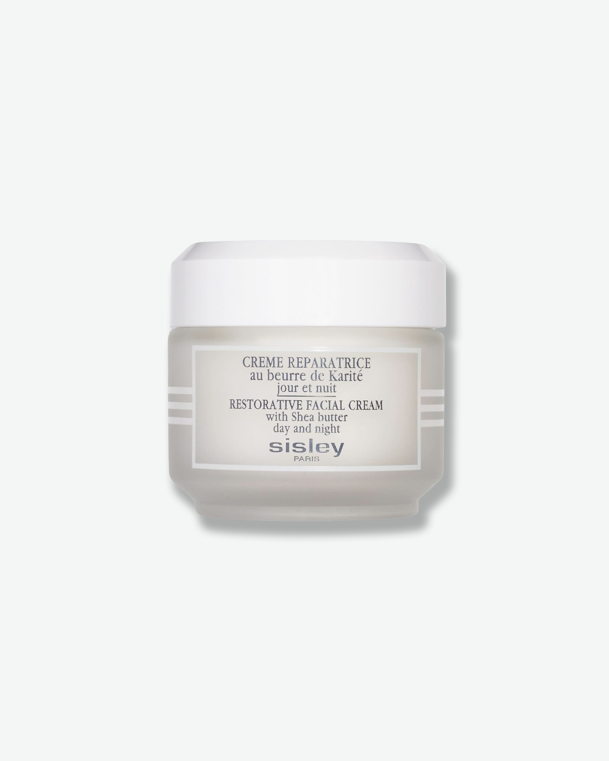 Front view of a Sisley Paris Restorative Facial Cream jar against a plain gray background. The cylindrical container features a frosted, light-grey glass base accented by white horizontal stripes on the sides, a rectangular white label with dark grey text, and a matching solid white screw-on cap.