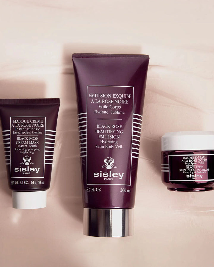 Sisley skincare products including a tube, cream mask, and balm on a beige background