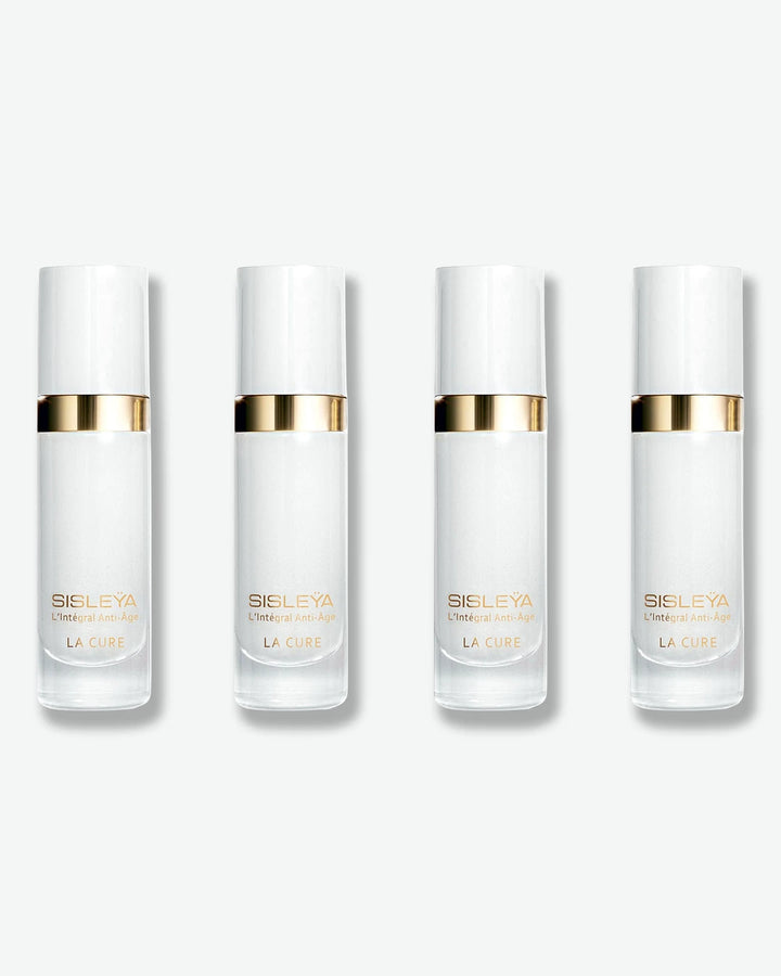 A row of four identical Sisley Paris Sisleÿa L'Intégral Anti-Âge La Cure serum bottles, featuring frosted white bodies and metallic gold neck collars.