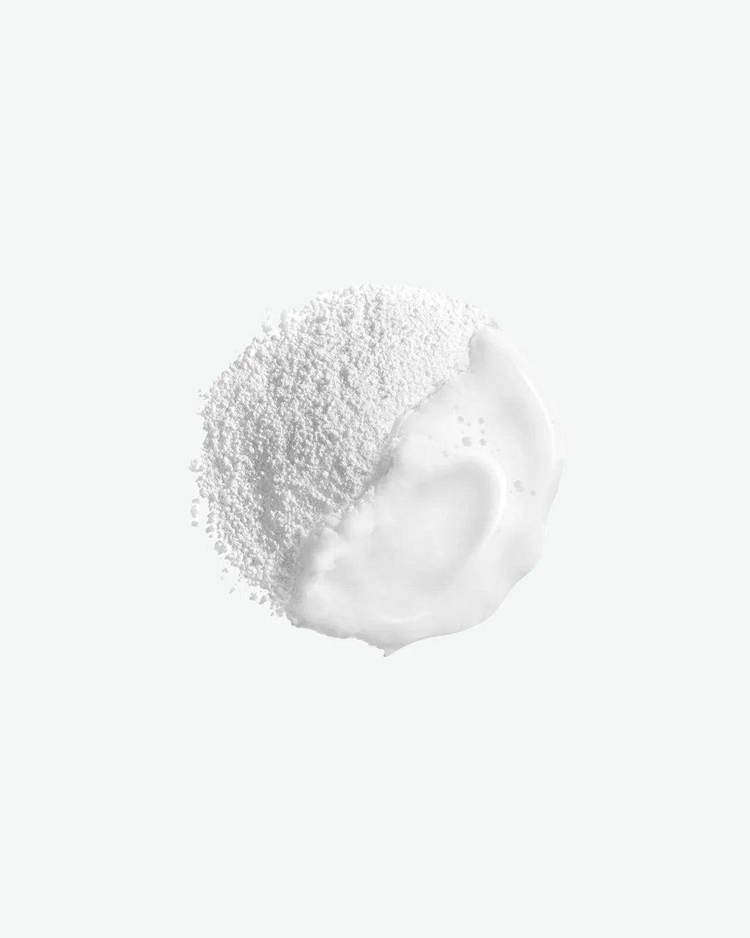 Close-up of a white cream with a textured top on a light gray background